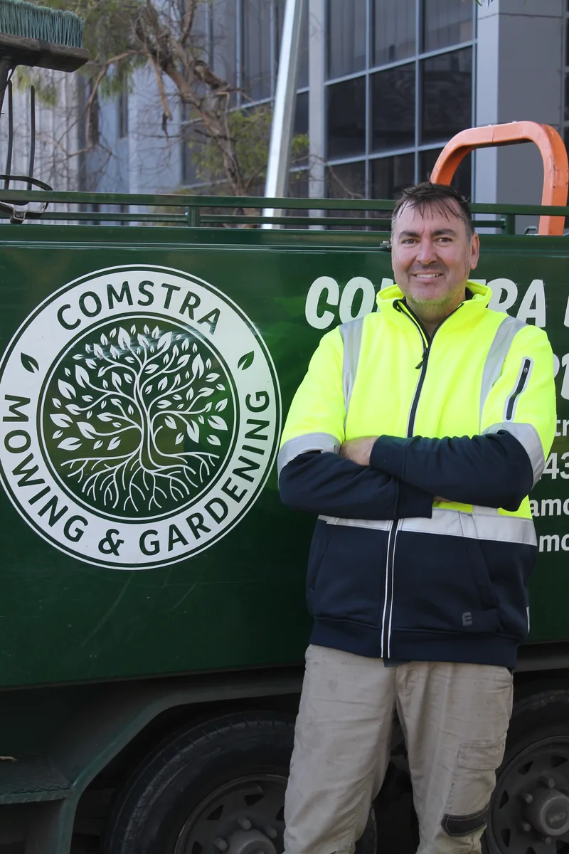 Neil Meredith, horticulturist at COMSTRA Mowing, beside the branded trailer
