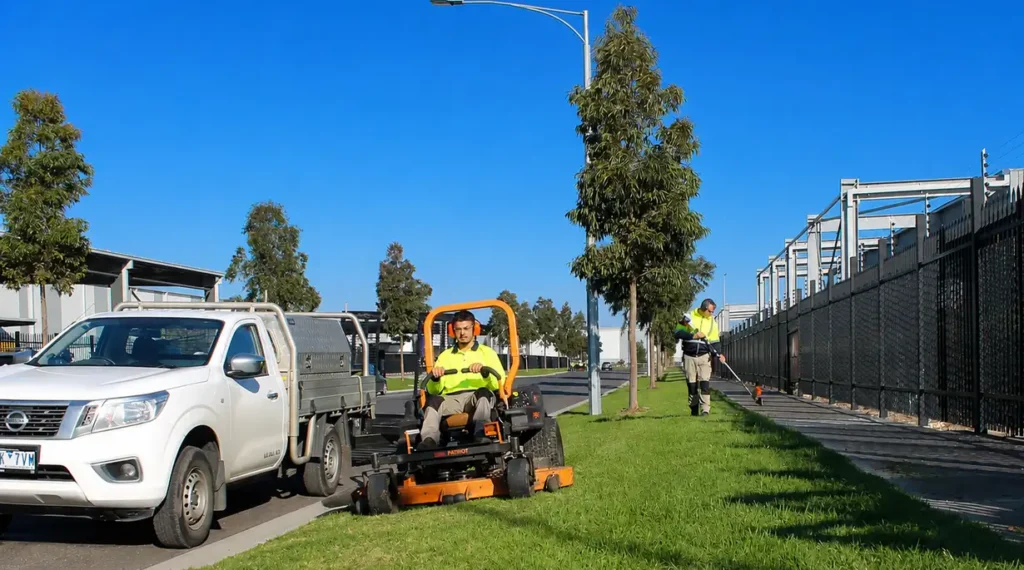 COMSTRA Mowing gardeners mowing and trimming a nature strip outside a commercial property in Tullamarine