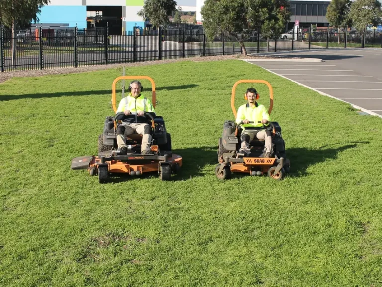 Two COMSTRA Mowing gardeners ride-on mowing a commercial estate lawn in Truganina